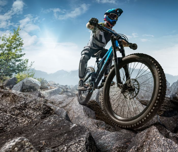 Steine und Adrenalin: Ein unerschrockener Mountainbiker erklimmt einen felsigen Trail. (Foto: AdobeStock - Alex 220371915)